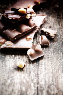 Ahşap arka plan üzerinde fındık ile kırık çikolata