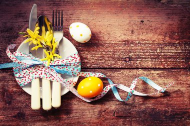 tabak, çatal, kaşık ve bıçak renkli boyalı Paskalya yumurtaları yanında tablo ayarı closeup görünümünü ahşap arka plan üzerinde