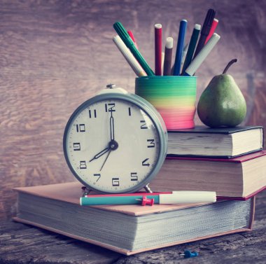 ahşap tablo üzerinde saatler, kitaplar ve farklı okul portre görünümünü sağlar