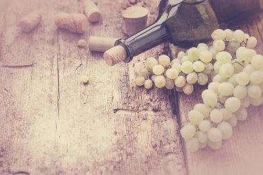 şişe beyaz şarap, üzüm ve mantarlar ahşap tablo