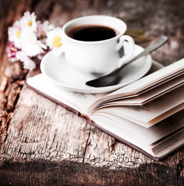 kahve fincanı çiçek ve ahşap masa kitap closeup görünümü