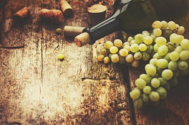 şişe beyaz şarap, üzüm ve mantarlar ahşap tablo