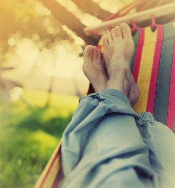 Erkek bacakları yeşil bahçesinde hamak döşeme 