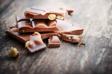 Ahşap arka plan üzerinde fındık ile kırık çikolata