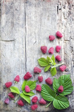 İştah açıcı ahududu ahşap masa yapraklarda ile