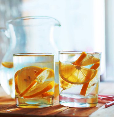 Kavanoz limonata ve iki kadeh tabloda limon dilimleri ile