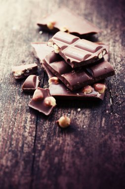 Ahşap arka plan üzerinde fındık ile kırık çikolata