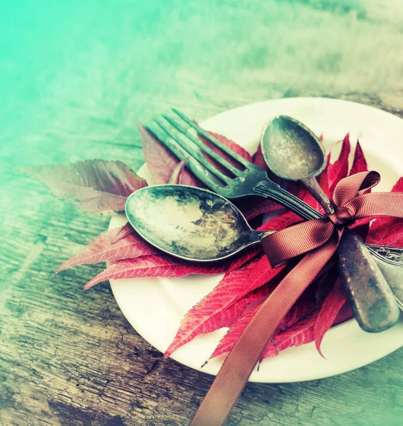 Nahaufnahme Von Teller Mit Herbstblättern Und Geschirr Über Holztisch — Stockfoto