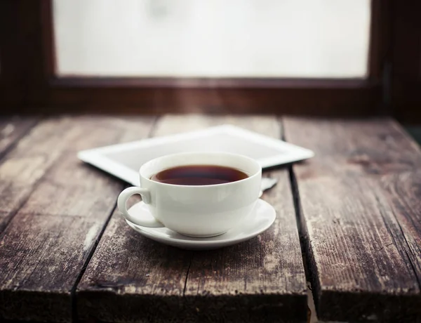 一杯の紅茶と木製の表面にデジタル タブレット — ストック写真