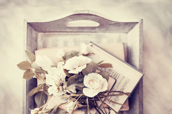 在木托盘上堆积的老书新鲜切玫瑰 — 图库照片
