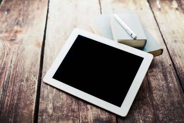 closeup view of digital tablet and notebooks lying on wooden table