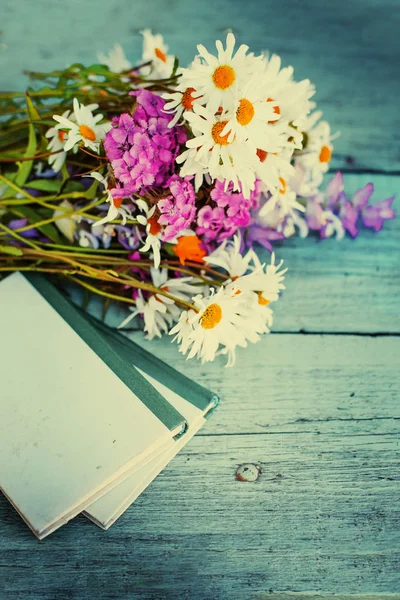 bouquet of rustic flowers on garden table with old books