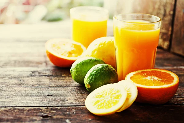 Orange juice with oranges on wooden background