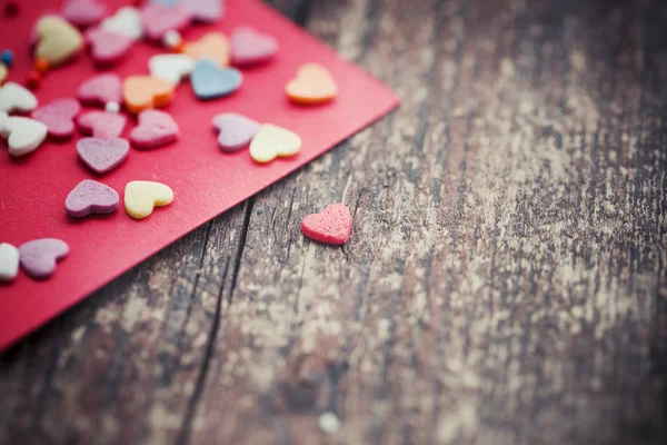 Ahşap Arka Plan Üzerinde Kırmızı Şablonuyla Renkli Romantik Kalpler — Stok fotoğraf