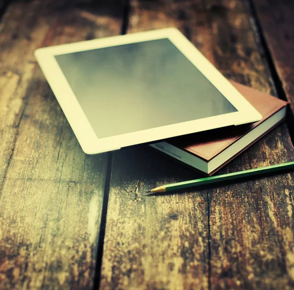 closeup view of digital tablet and notebooks lying on wooden table