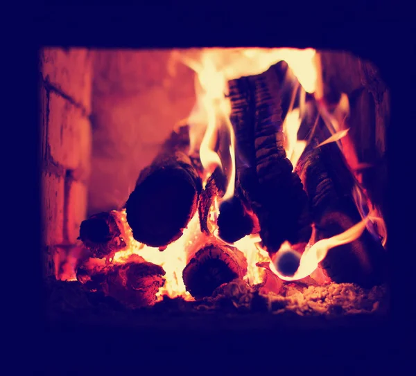 Burning wood in fireplace with big spurts of flame