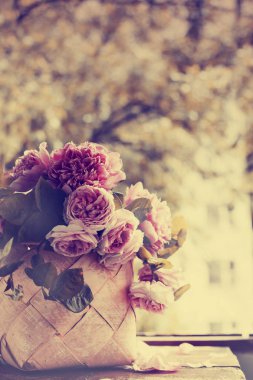 ahşap masa üzerinde sepet içinde yapraklarla taze peonies