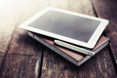 closeup görünümünü dijital tablet ve ahşap masanın üzerinde yatan pikap iğnesi