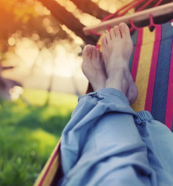 Erkek bacakları yeşil bahçesinde hamak döşeme 
