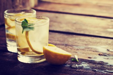ahşap masa üzerinde bardaklarda taze ev yapımı limonata