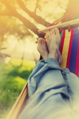 Erkek bacakları yeşil bahçesinde hamak döşeme 