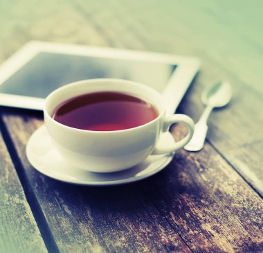 çay ve dijital tablet ahşap masanın üzerinde yatan closeup görünümü