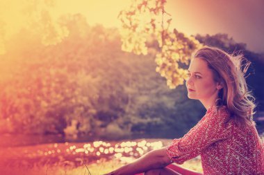 Beautiful young woman in summer dress on nature dreamy background