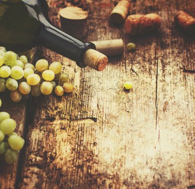 şişe beyaz şarap, üzüm ve mantarlar ahşap tablo