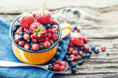 taze yaban mersini, çilek ve kupa ahşap yüzey üzerinde yaban çilekleri