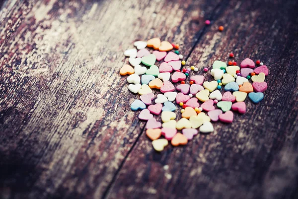 Colorful romantic hearts on wooden background