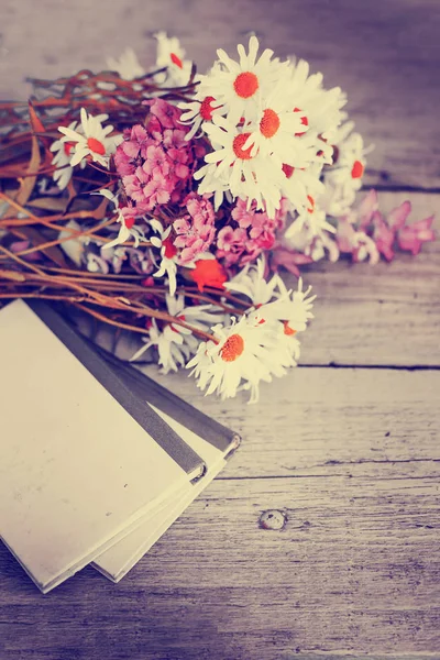 bouquet of rustic flowers on garden table with old books