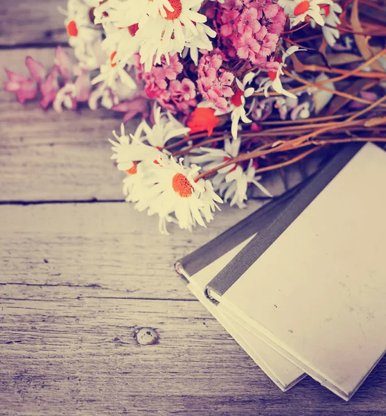 古書のガーデン テーブルの上の素朴な花の花束 — ストック写真
