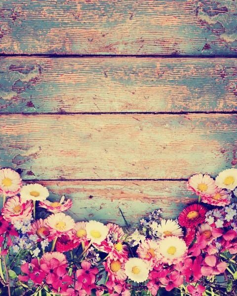 ぼろぼろの木製の背景にカラフルな生花 — ストック写真