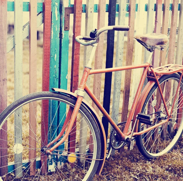 vintage bicycle standing by colorful fence