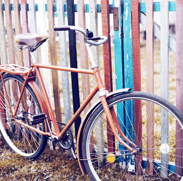 vintage bicycle standing by colorful fence