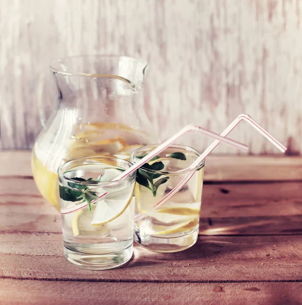 新鲜的自制柠檬水在壶和玻璃在木桌上 — 图库照片