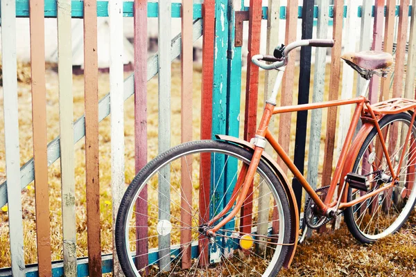 vintage bicycle standing by colorful fence