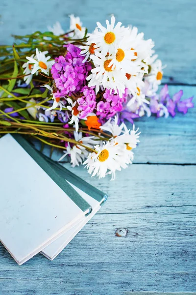 古書のガーデン テーブルの上の素朴な花の花束 — ストック写真