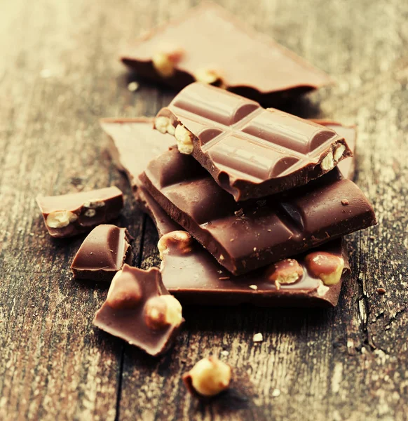 Ahşap Arka Plan Üzerinde Fındık Ile Kırık Çikolata — Stok fotoğraf