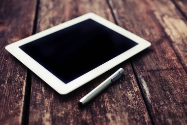 closeup görünümünü dijital tablet ve ahşap masanın üzerinde yatan pikap iğnesi
