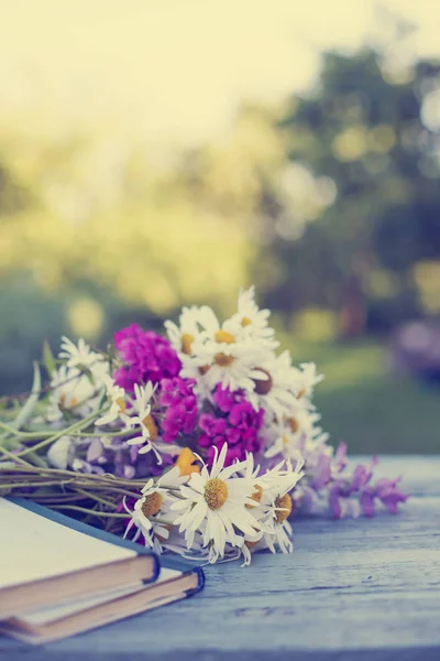 本庭の木製テーブルにカラフルな野生の花の花束 — ストック写真