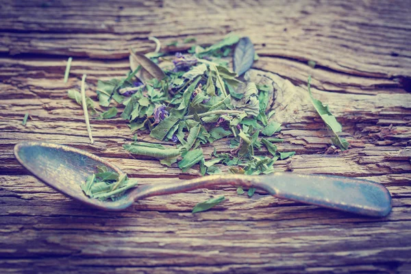 closeup view of dry tea herbs over wooden background