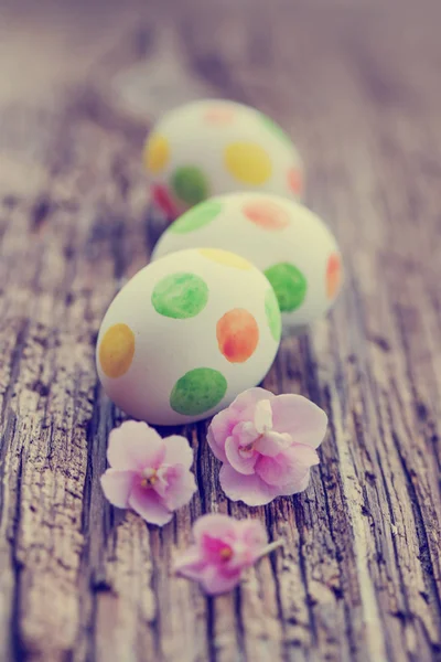 Bunt Bemalte Eier Mit Rosa Blumen Auf Hölzernem Hintergrund — Stockfoto