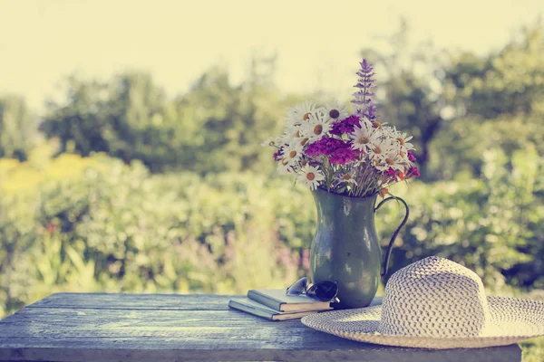 ぼやけて自然背景を持つ木製のテーブルの上の花瓶立っての野生の花 — ストック写真