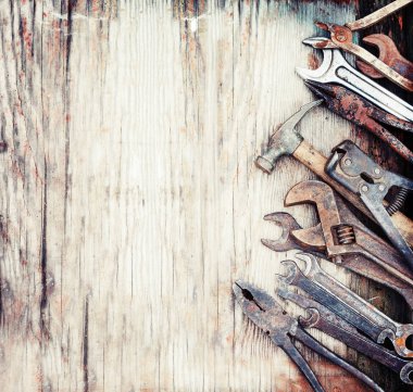ahşap bir masa üzerinde eski paslı el araçlar kümesi