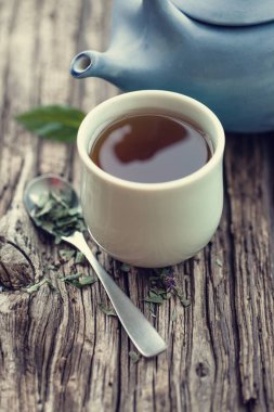 closeup görünümü taze çay Kupası ile ahşap masa üzerinde mavi çaydanlık