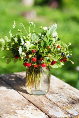 Yaban çilekleri ve yaban mersini yaprak ve Çiçek vazosu ile taze demet