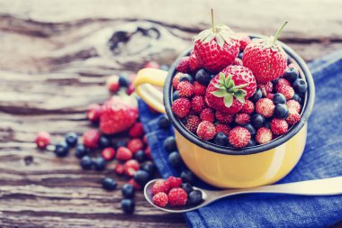 taze yaban mersini, çilek ve kupa ahşap yüzey üzerinde yaban çilekleri