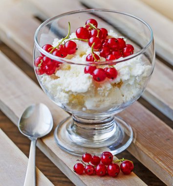 kırmızı meyveler ve ahşap masa kaşık ile cam kapta beyaz dondurma