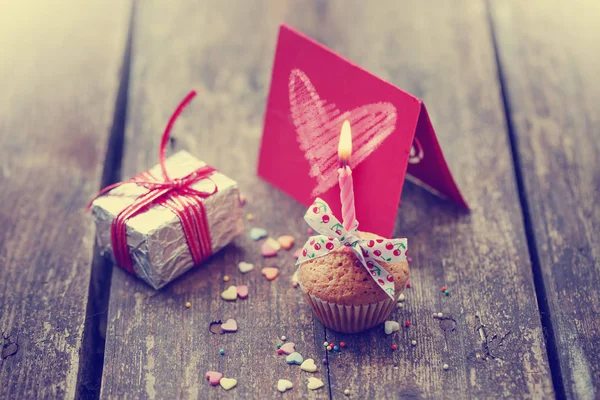 close-up view of cupcake with candle and colorful decoration on wooden background